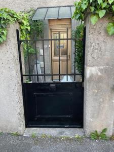 een zwarte deur met een hond erin bij Chez Mary et Stef in Verdun-sur-Meuse