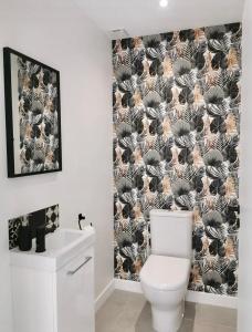 La salle de bains est pourvue de toilettes et d'un rideau de douche noir et blanc. dans l'établissement Le Repère de B&C, à Cenon