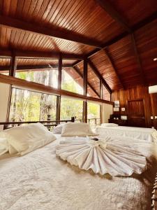 Cirandeira Amazon World EcoResort في Manacapuru: غرفة نوم بسريرين ونافذة كبيرة