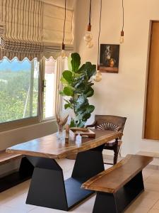 un comedor con una mesa de madera y una planta en Mulberry tree villa, en Agios Nikolaos