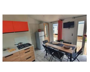 a kitchen and dining room with a table and chairs at Camping Ty Nénez in Pont-Scorff