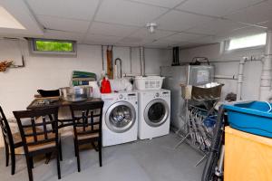 uma cozinha com uma máquina de lavar roupa e uma mesa em Cozy Greenport Cottage em Greenport