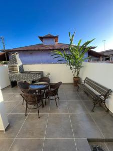 un patio con banco, mesa y sillas en Meu Loft Barra Nova 4 en Saquarema