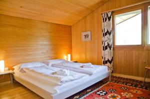 a bed in a wooden room with a window at Chalet Adele in Grindelwald