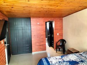 een slaapkamer met zwarte deuren en een bakstenen muur bij Casa San Daniel in Paipa