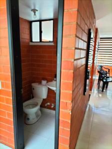 La salle de bains est pourvue de toilettes et d'un mur en briques. dans l'établissement Casa San Daniel, à Paipa