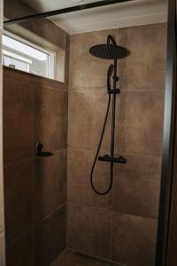 a bathroom with a shower with a shower head at De Os aan de dijk in Grafhorst