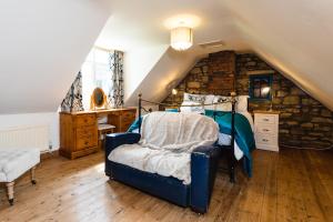 a bedroom with a bed and a chair in a attic at The Poachers Pocket in Whittingham