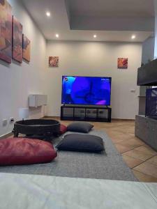 uma sala de estar com uma grande televisão de ecrã plano em The Garden House Relax em Rocca di Papa