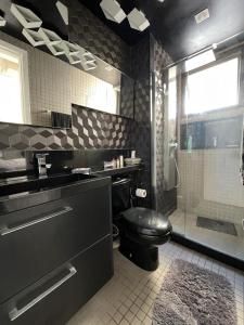 uma casa de banho com um WC preto e um chuveiro em Lindo Apto com Escritório, Varanda e Garagem no Centro de Niterói em Niterói
