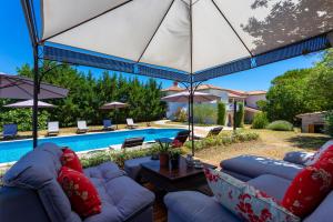 RakaljにあるKapetanova Villaのパティオ(ソファ、パラソル、プール付)