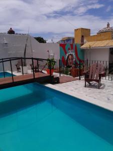 a swimming pool with two chairs next to a building at Xtabentun Hostal in Cancún