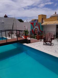 una piscina con 2 sillas junto a un edificio en Xtabentun Hostal, en Cancún