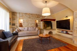 RakaljにあるKapetanova Villaのソファと暖炉のあるリビングルーム