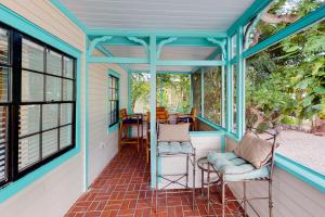 a screened porch with two chairs and windows at Turquoise Turtle Manor in Tavernier