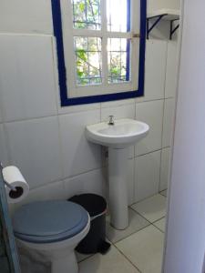 baño con lavabo y aseo y ventana en Casa da tranquilidade en Ouro Preto