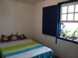 Habitación pequeña con cama y ventana en Casa da tranquilidade en Ouro Preto
