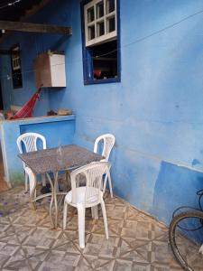 uma mesa e cadeiras em frente a uma parede azul em Casa da tranquilidade em Ouro Preto