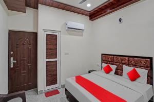 um quarto com uma cama com almofadas vermelhas e uma porta em Flagship Shree Shyam Residency em Nova Deli