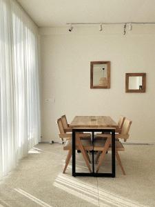 グリゴレティにあるLIMANIの窓のある部屋で、テーブルと木製の椅子2脚が備わります。
