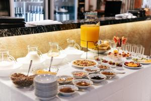 ein Buffet mit Speisen und Getränken auf dem Tisch in der Unterkunft Hotel Plaza Central Canning in Ezeiza