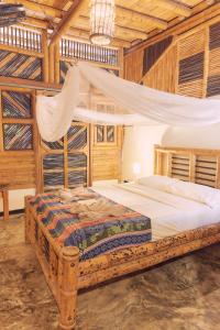 a bedroom with a bed in a room with wooden walls at Coco Sänkala Hostel in Palomino