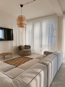 um quarto branco com uma cama grande e um sofá em LIMANI em Grigoleti