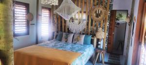 ein Schlafzimmer mit einem Bett in einem Zimmer mit Fenstern in der Unterkunft Casa Mandala - Pousada Icaraí Kite Village in Icaraí