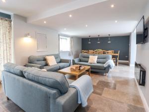ein Wohnzimmer mit zwei Sofas und einem Tisch in der Unterkunft Ysgubor Tyddyn Isaf in Derwen