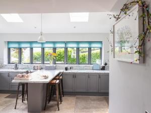 a kitchen with gray cabinets and a large island at Ysgubor Tyddyn Isaf in Derwen