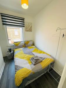 a bedroom with a bed with yellow and white stripes at Modern House Liverpool in Liverpool