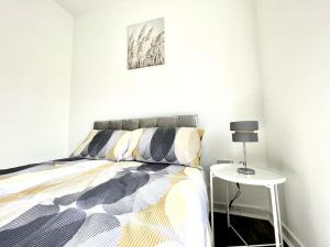 a bedroom with a bed and a side table at Modern House Liverpool in Liverpool