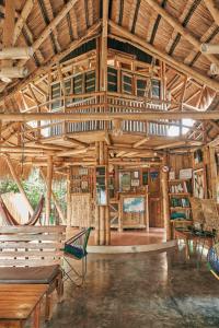 Coco Sänkala Hostel في بالومينو: غرفة كبيرة بسقوف خشبية وطاولات وكراسي
