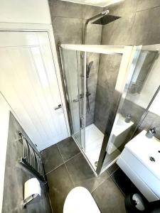 uma casa de banho com um chuveiro, um WC e um lavatório. em Modern House Liverpool em Liverpool