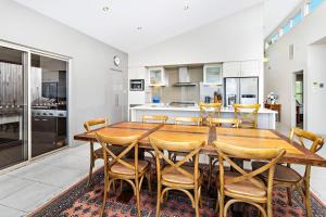 een keuken en eetkamer met een houten tafel en stoelen bij Vue De La Mer Gerroa in Gerroa