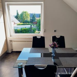 una sala da pranzo con tavolo, sedie e finestra di Ferienwohnung Jessica a Mastershausen