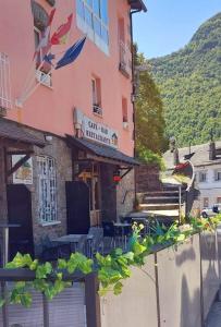 un edificio rosa con un cartel para un restaurante en Apartahotel portal de leon, en Caboalles de Abajo