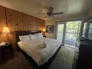 um quarto com uma cama e uma ventoinha de tecto em C10, Two bedroom, two bath log-sided, lake view, luxury Harbor North cottage with hot tub cottage em Mount Ida