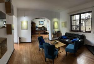 a living room with a black couch and blue chairs at El Museo Hotel Boutique in La Paz
