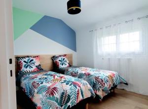 a bedroom with two beds next to a window at Gîte de la valleuse, capacité 12 personnes, idéal pour une grande famille in Senneville-sur-Fécamp