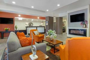 a living room with orange furniture and a fireplace at Best Western Plus Downtown North in San Antonio