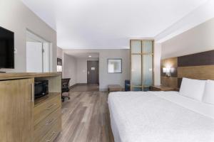 a hotel room with a bed and a flat screen tv at Best Western Plus Downtown North in San Antonio +28 photos