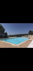 a large swimming pool with blue water at La cigale et la fourmie in Le Castellet