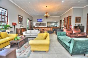 a large living room with couches and chairs at Hibon Lodge in Hekpoort
