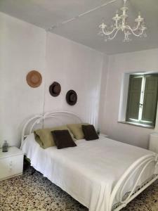 a white bedroom with a white bed and a chandelier at Romantic Casa Rurale Le Masche in Rivara