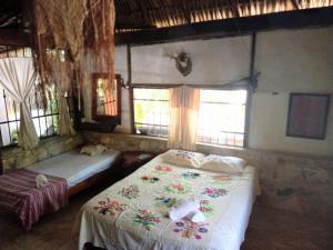 a bedroom with two beds and two windows at Ecolodge Uh May in Francisco Uh May