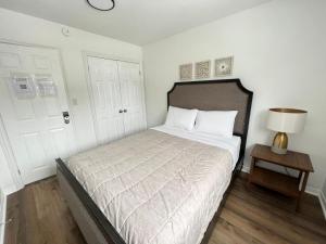 um quarto com uma cama, um candeeiro e uma porta em Letitia Heights !C Quiet and Modern Private Bedroom with Shared Bathroom em Barrie