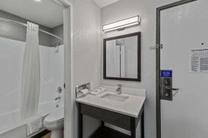 La salle de bains est pourvue d'un lavabo, de toilettes et d'un miroir. dans l'établissement Motel 6 Brighton CO Denver Northeast, à Brighton