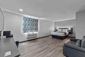 a living room with a bed and a couch at Motel 6 Brighton CO Denver Northeast in Brighton +23 photos