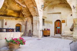 an old building with a courtyard with flowers in a basket at Gibos Cave Hotel in Ürgüp